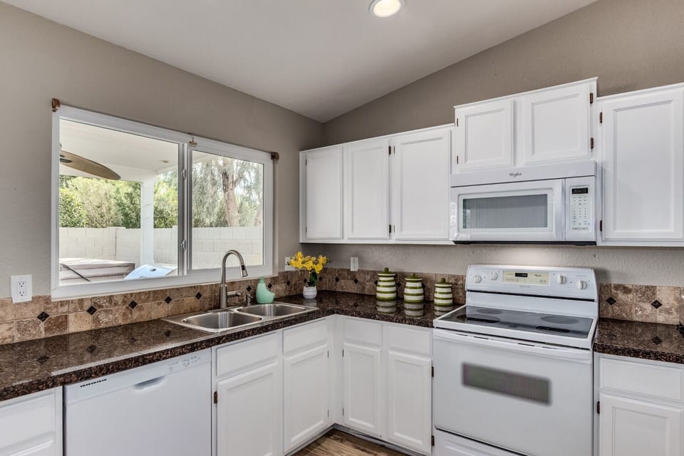 Well stocked kitchen with coffee maker, toaster oven, blender, spice rack & more