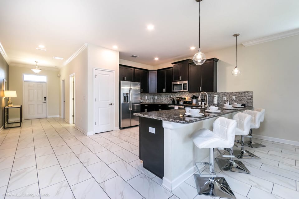 Inviting Kitchen of the Home in Davenport Florida - This modern kitchen comes with beautiful granite counter tops  - Stainless steel appliances, along with everything you need to cook up - High Chairs and Breakfast bar