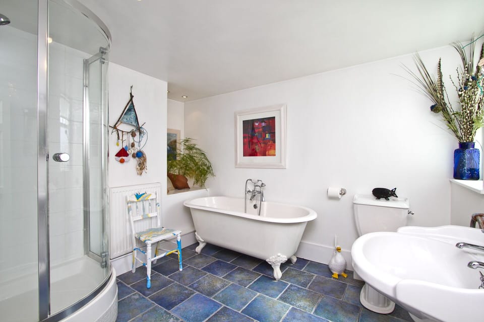 Bright, spacious, family bathroom with tiled floor & original artwork.