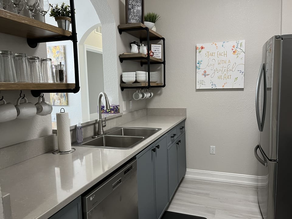 The kitchen is fully stocked with dishes, appliances and cookware.
