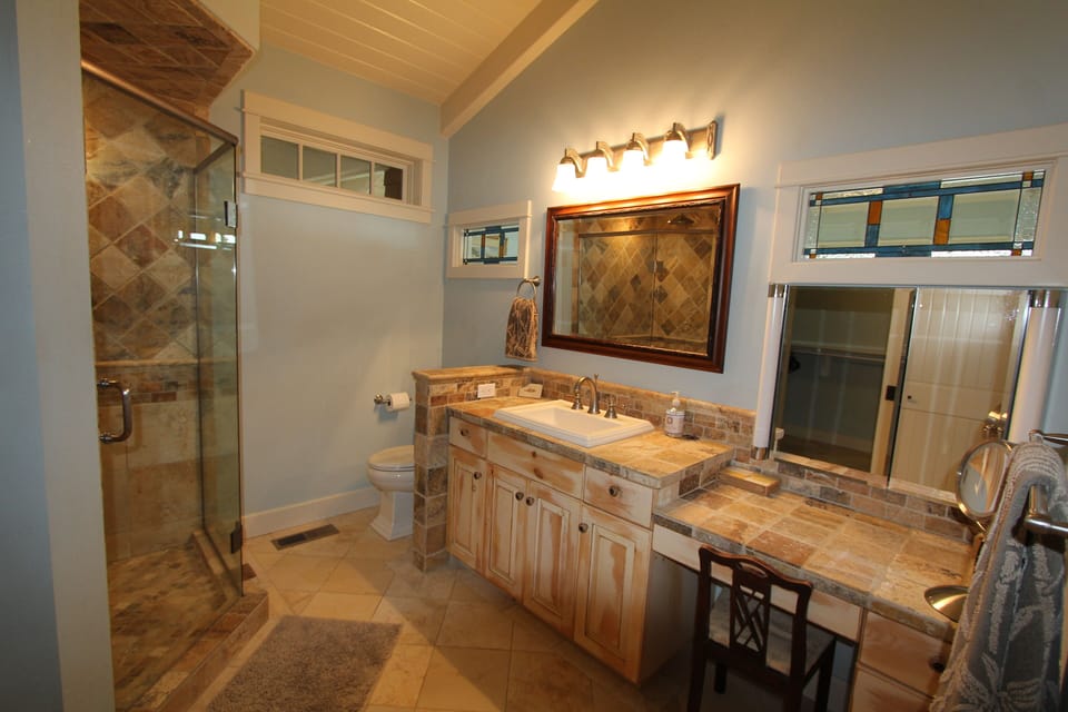 Our spacious master bath has a large shower for two, and travertine tile through