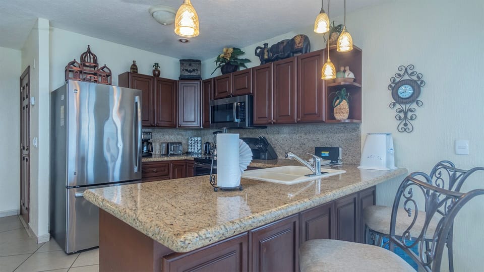 The complete kitchen, countertop tea and bar stools.