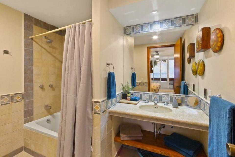 Medium size bathroom with shower/tub with plush linens blow dryer and extra toiletries