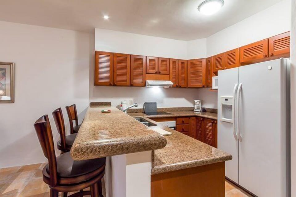 A long granite breakfast counter has seating for three