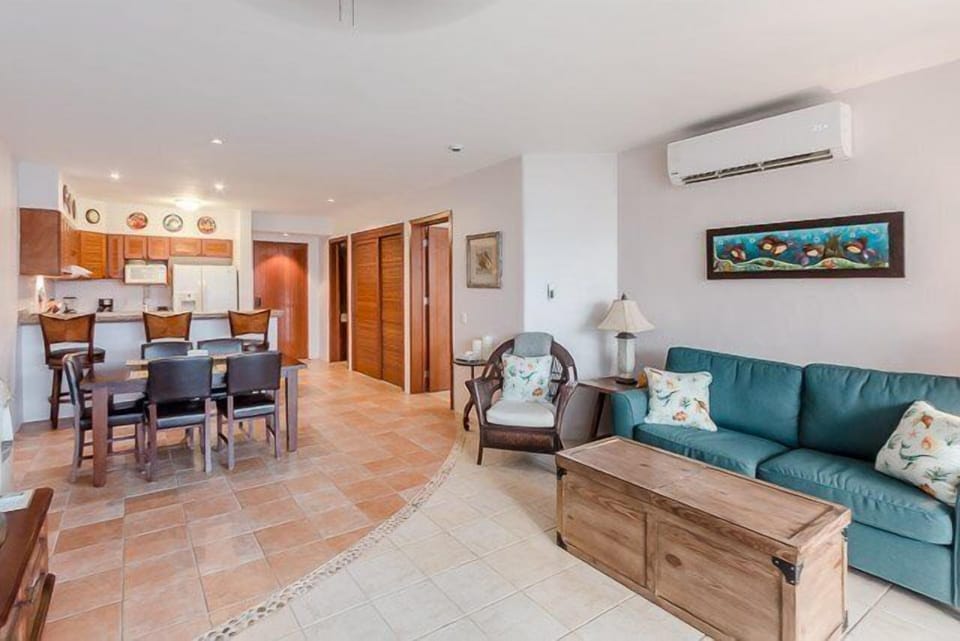 The living room has a TV, lots of seating and is adjacent to the dining room and kitchen