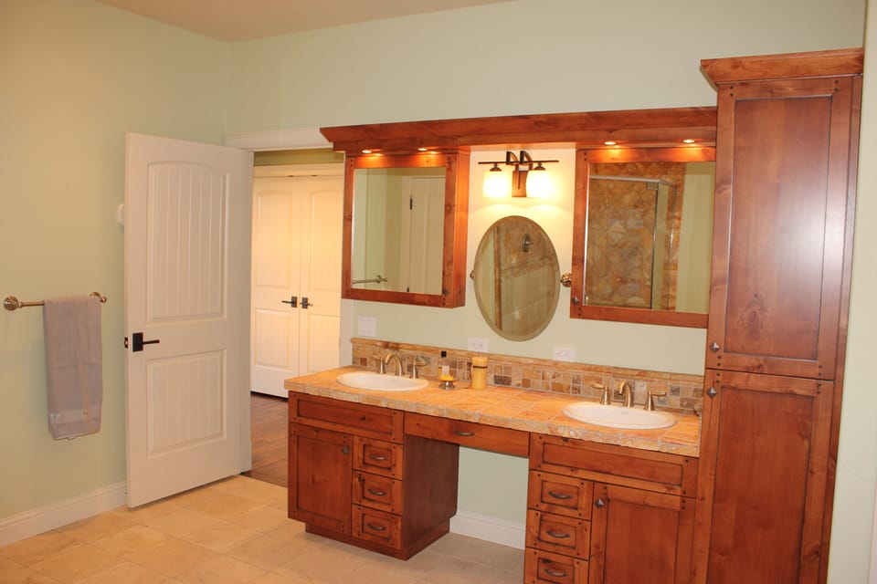 Master bath has custom alder cabinets and travertine tile throughout