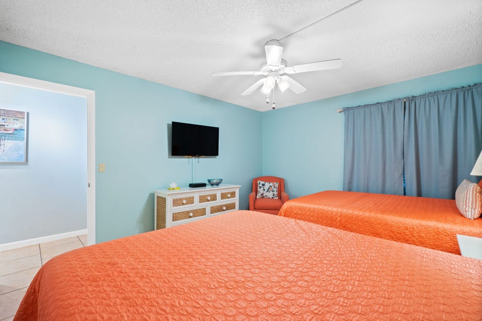 Master bedroom with 2 queen beds, en-suite bathroom, and smart TV.