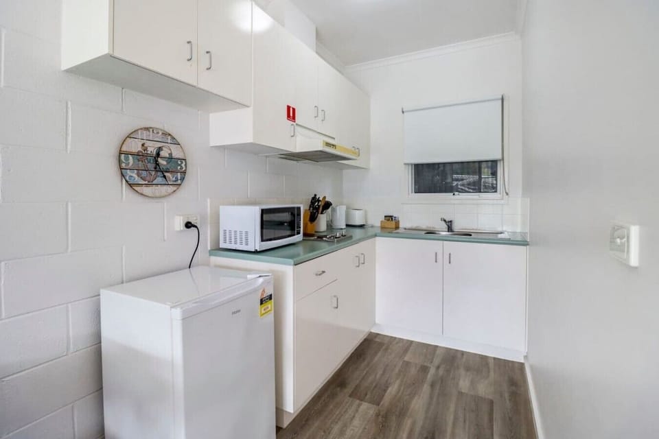 Compact kitchenette with fridge, microwave and essentials for easy self-catering stays.