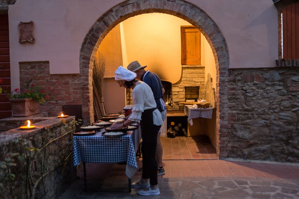 Preparing pizza in front of the old wood-burning oven.