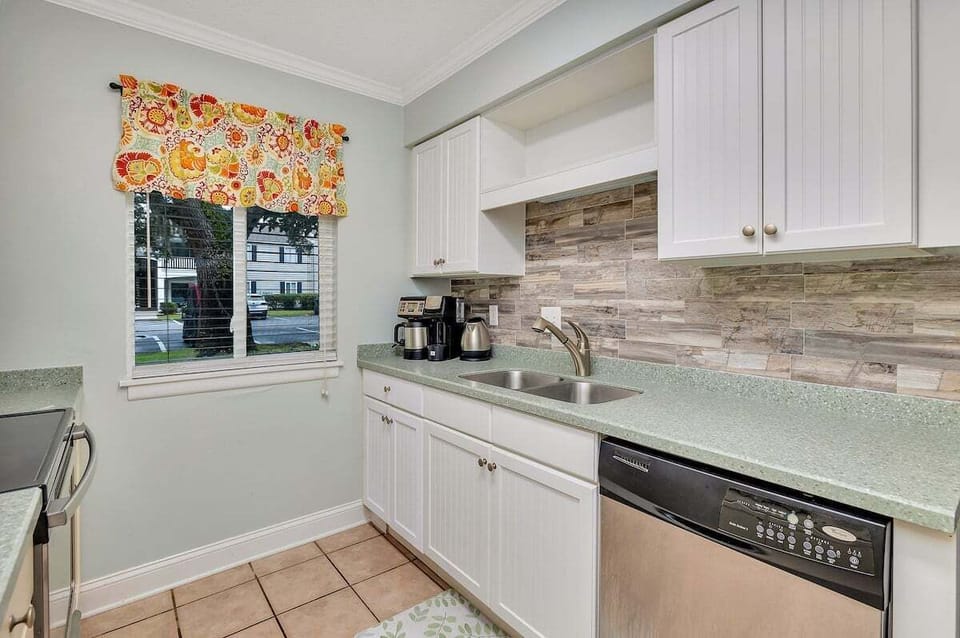 Ocean Walk N4 - Kitchen with white cabinets, stone backsplash, and green counters