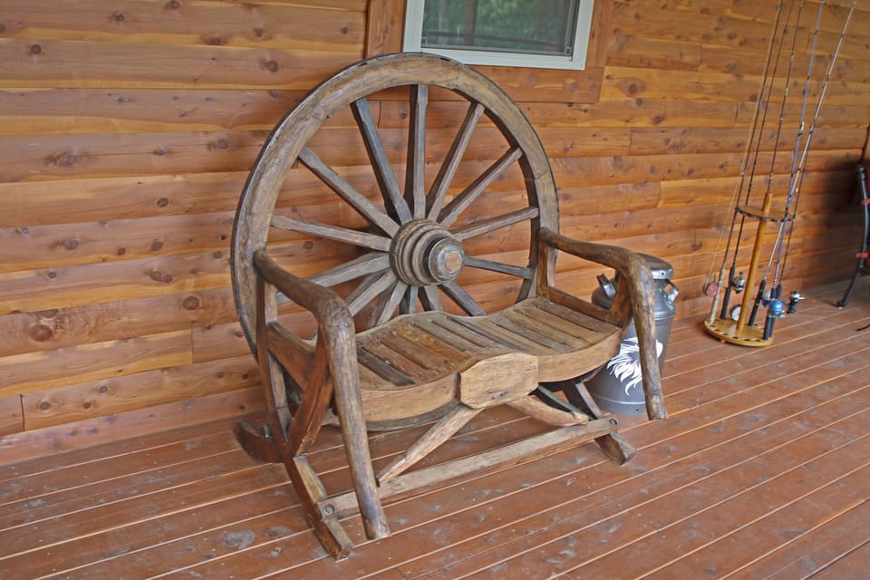 Relax on the enclosedback porch on our antique wagonwheel bench!