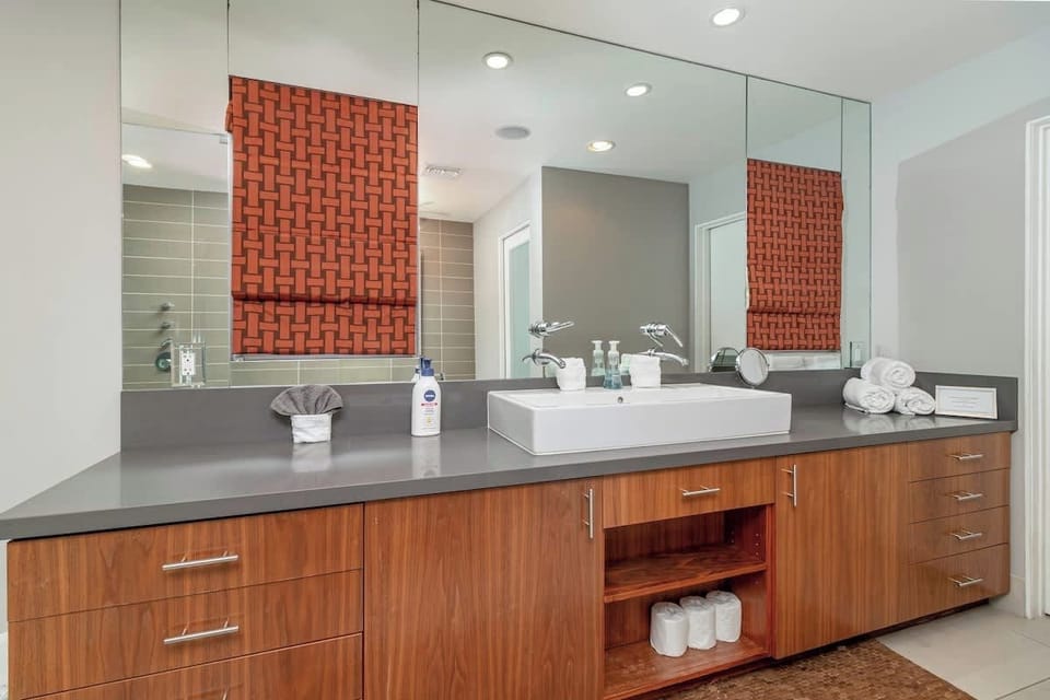 Bright Bathroom with wall size mirror to get ready in.