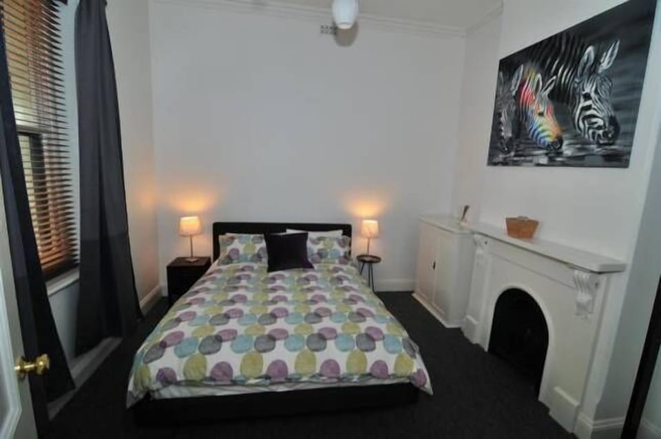 First Bedroom Queen Bed Ornate Fire Place Natural Wool Carpets Shutters & Drapes