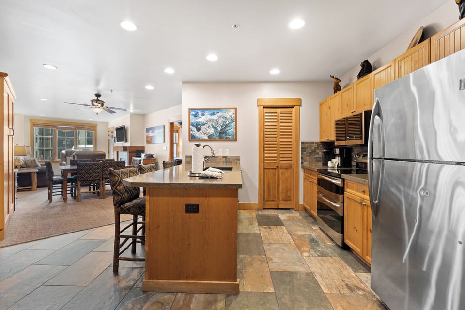Your spacious mountain retreat features a fully-equipped kitchen with stainless appliances, granite counters, and breakfast bar seating.