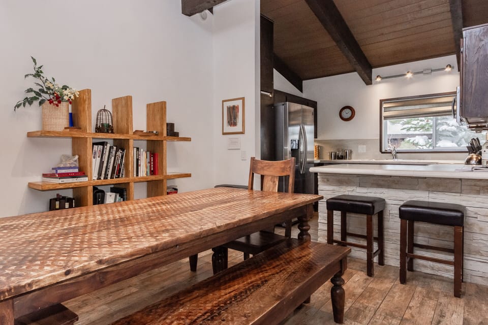 Main dining area sets 10 adults. 8 at large table, 2 at bar. Halogen lights.