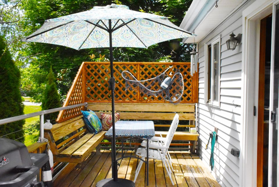 Spacious 24' deck off the living room with grill, table, umbrella and seating. 