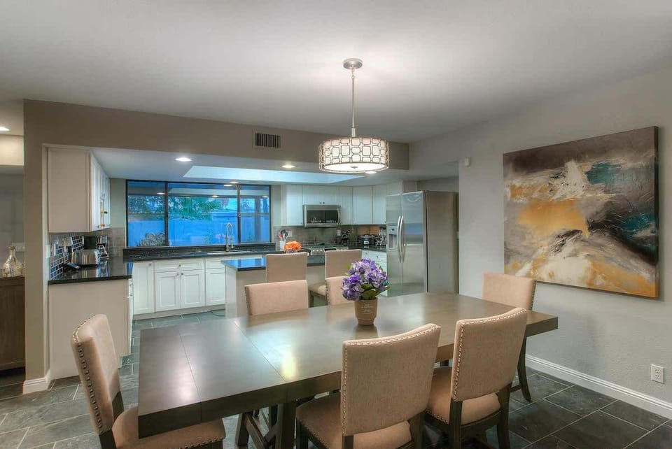 This white chandelier and a large abstract painting give the space an elegant feel.