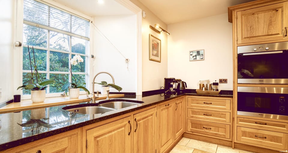 Modern kitchen with conventional cooker and microwave, and coffee maker.