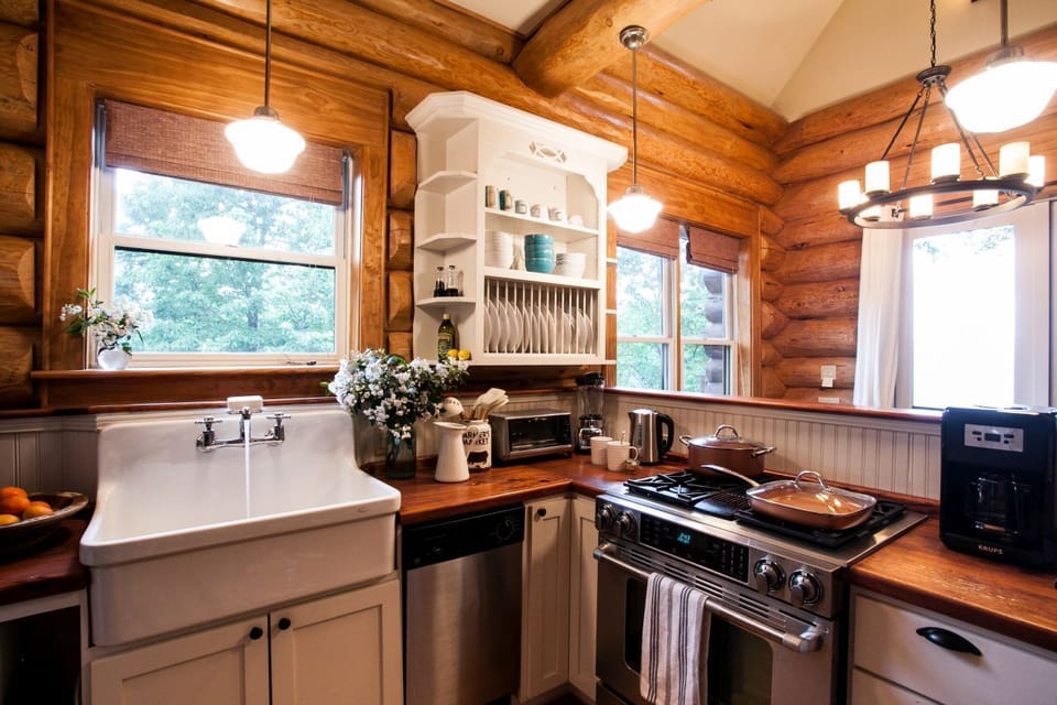 Galley kitchen with farmhouse sink, gas range, and drip-style coffee maker. Note: The water dispenser in the refrigerator door does not work.