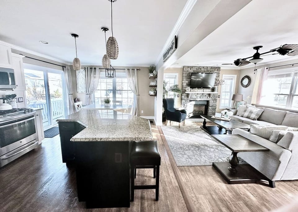Experience the best of open-concept living in this bright, airy space. Guests can easily move from the modern kitchen with its large granite island to the cozy living room, making it the perfect hub for socializing and shared meals.