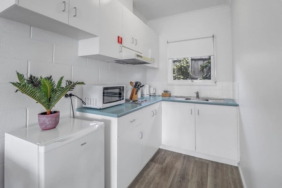 Compact kitchenette with fridge, microwave and essentials for easy self-catering stays.