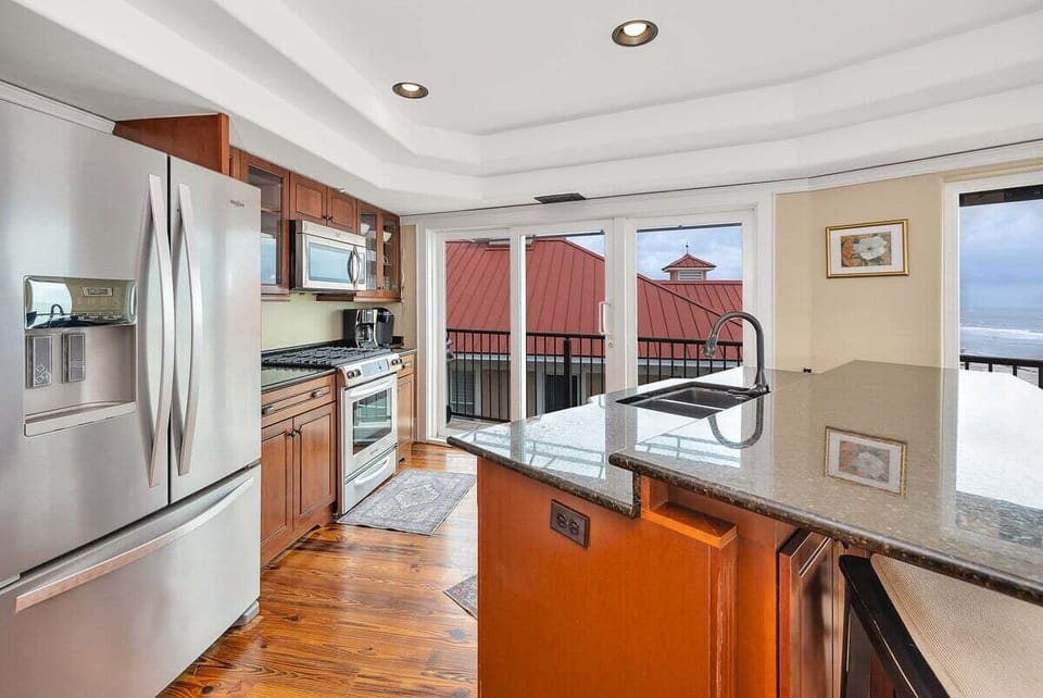 Kitchen with wood cabinets, stainless appliances, and balcony views