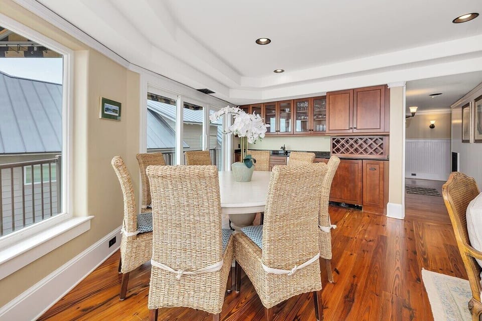 Dining area with wicker chairs, white table, and wood cabinets
