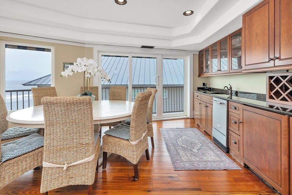 Dining area with wicker chairs and balcony views beyond