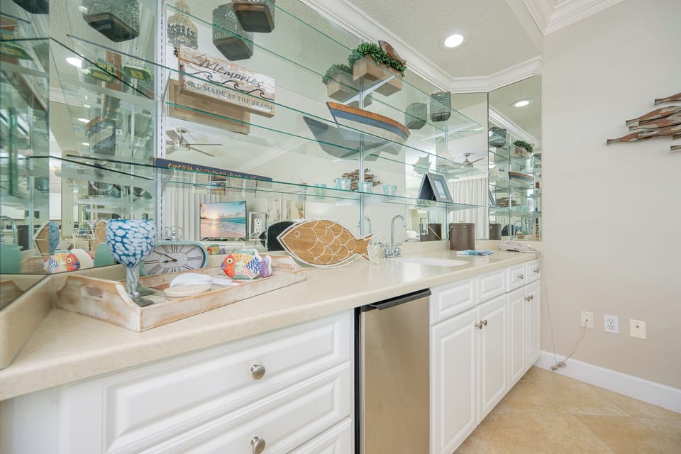 Experience delightful moments preparing your favorite drinks at the stylish wet bar with coastal decor