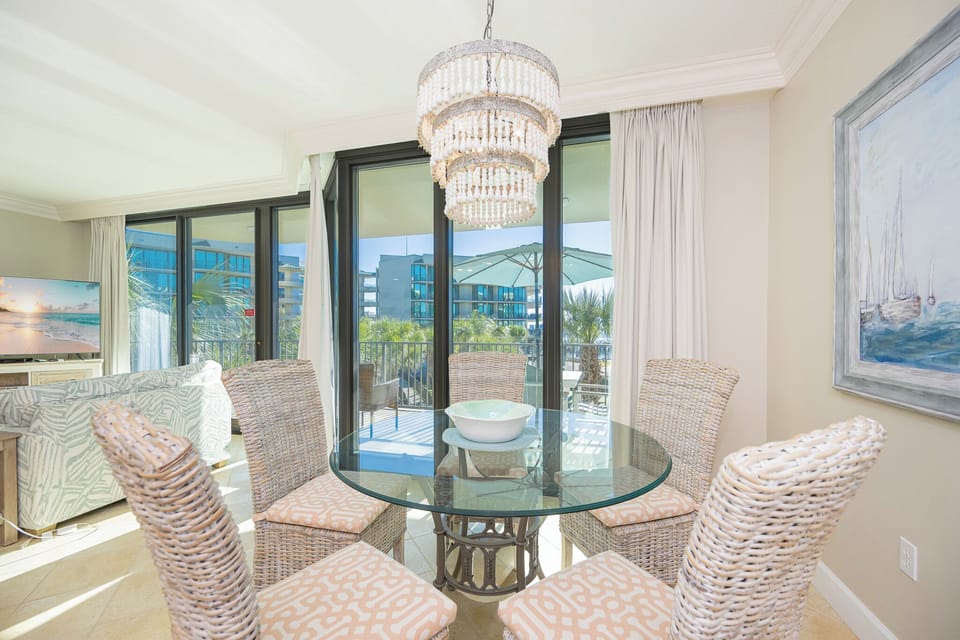 Delight in tranquil moments at the glass dining table, with the inviting sunshine streaming through expansive windows