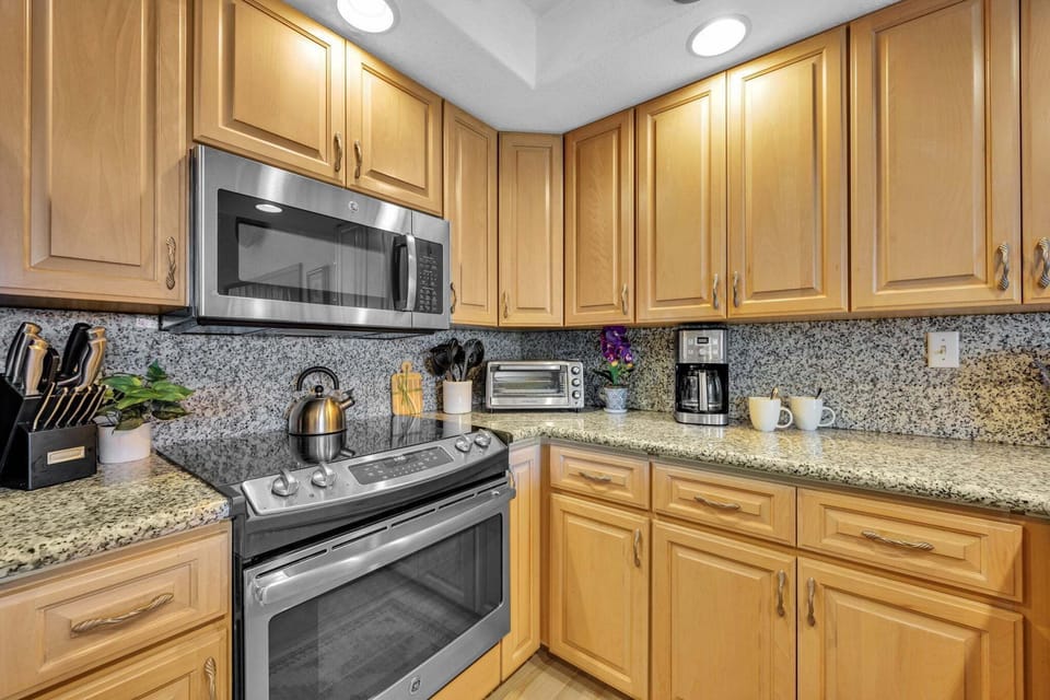 Kitchen features custom cabinets, lighting and counter tops