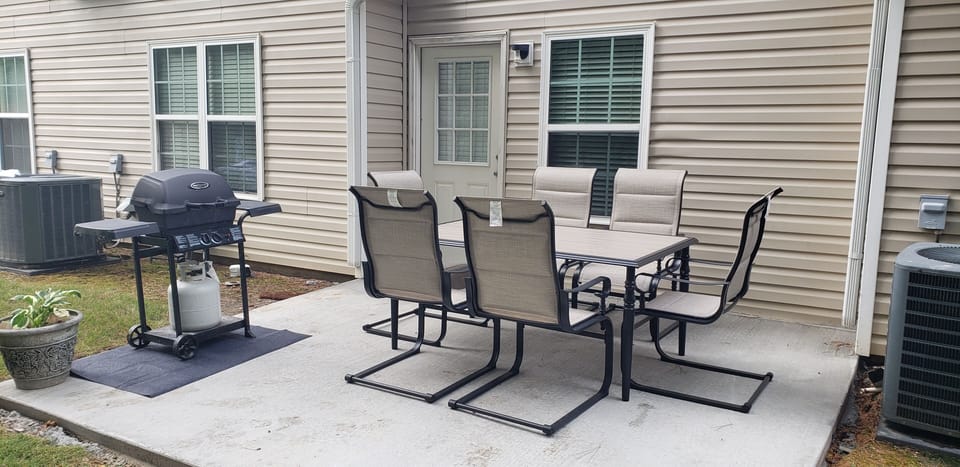 Back patio, table, and gas grill.