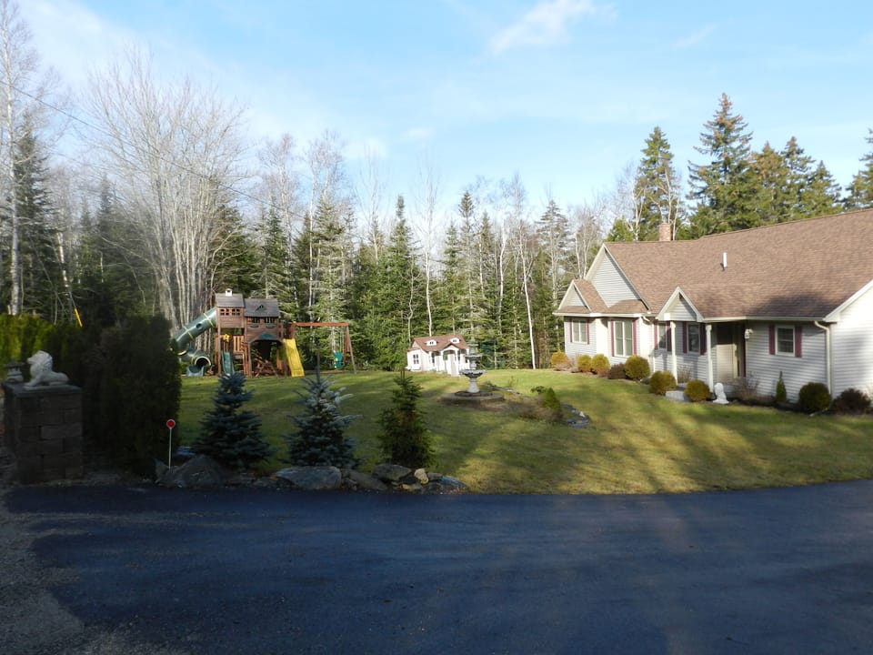 Front of home with playhouse, basketball and playcenter