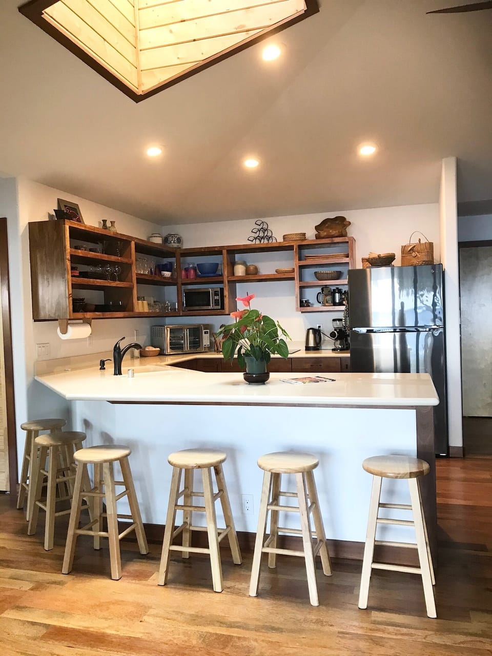 Open kitchen with custom built in Koa wood shelving