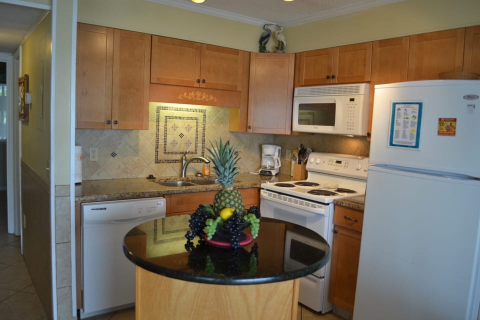 Kitchen with dishwasher, stove, microhood, and refirgerator.  