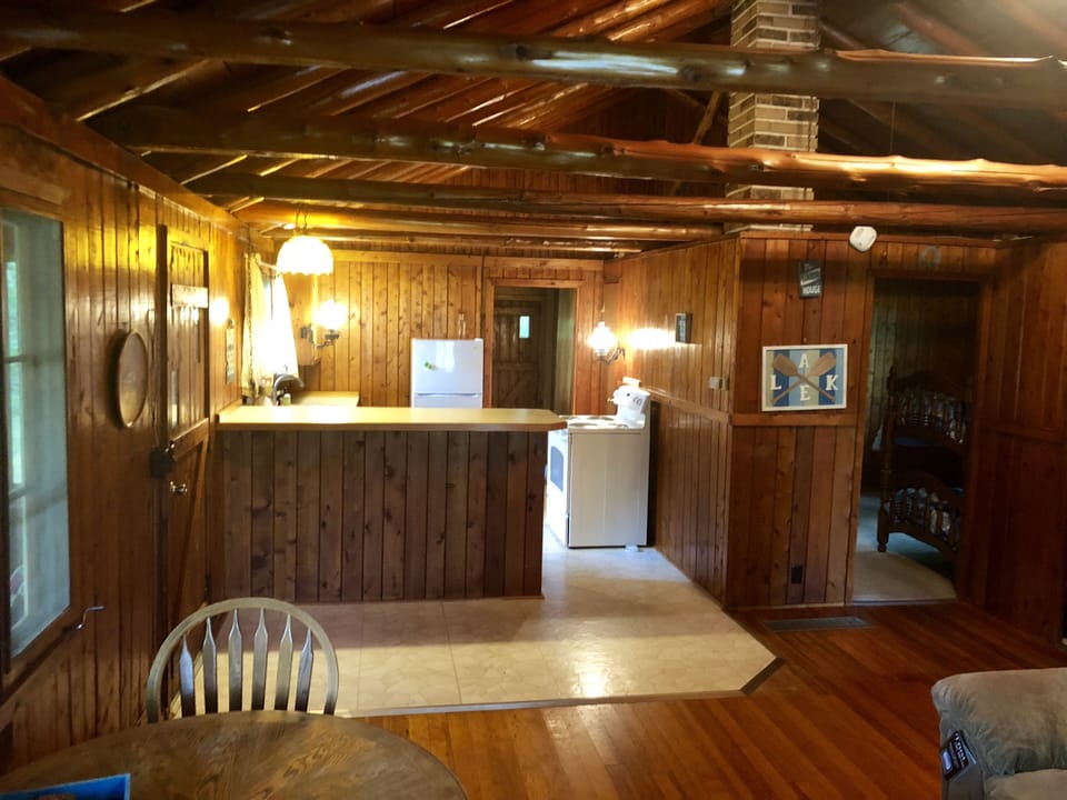Kitchen with bar top, fridge, microwave, stove, coffee maker, and stocked 