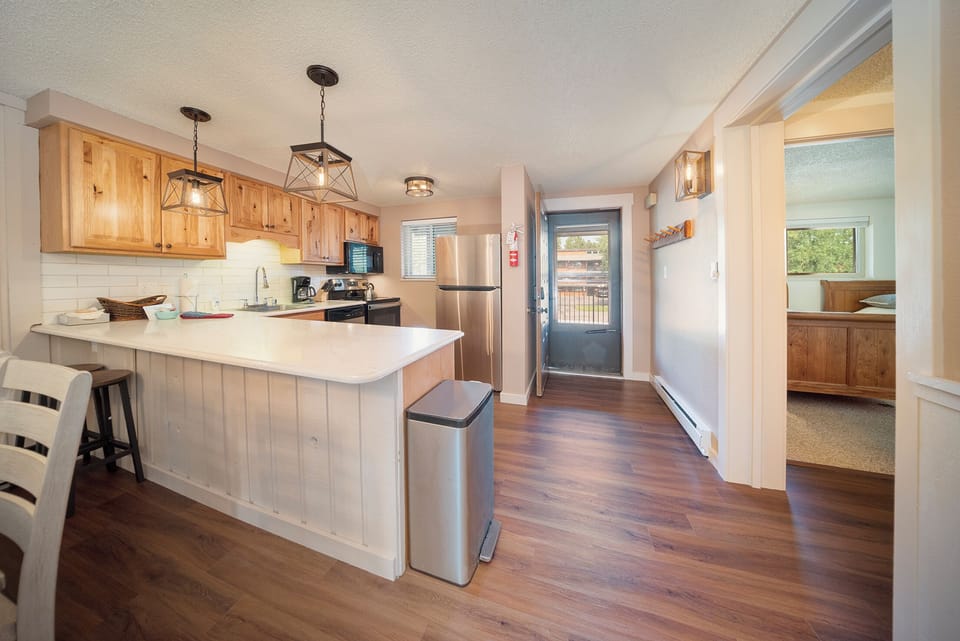 Cook your favorite meals in this beautifully appointed kitchen featuring warm wood cabinets, modern appliances, and a convenient island for prep work and casual dining.