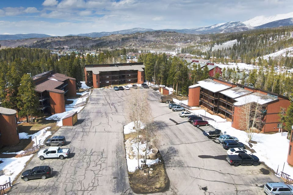 Mountain resort property nestled in snowy wilderness with convenient parking and forest surroundings.