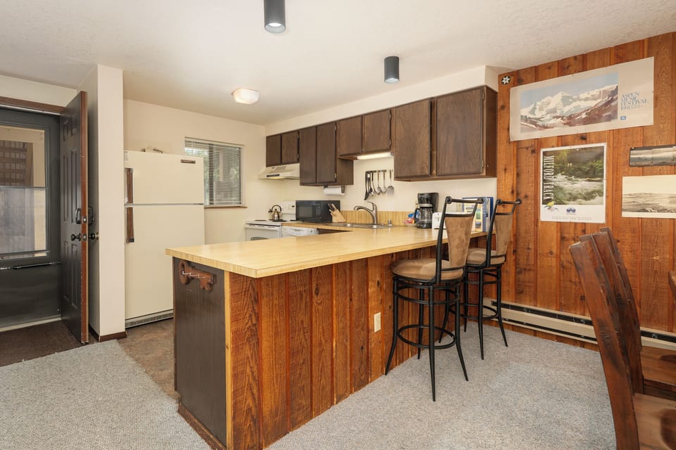 Your fully equipped kitchen offers everything needed for memorable meals, with warm wood finishes creating a cozy mountain atmosphere.