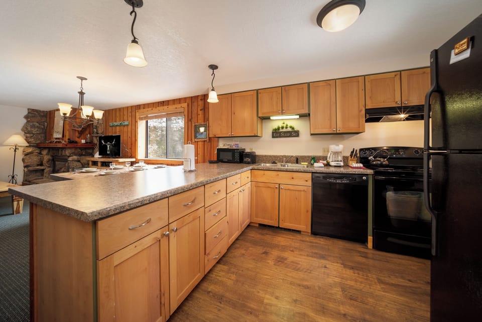 Cook memorable meals in this spacious kitchen with granite counters, modern appliances, and cozy fireplace views.