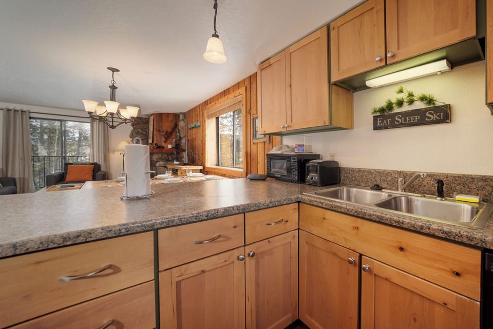 Your fully equipped kitchen awaits with granite counters, wood cabinets, and mountain cabin charm for memorable meal prep.
