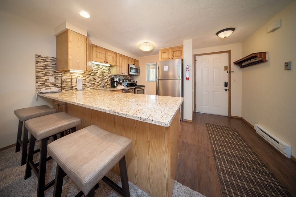 Your modern kitchen features granite countertops, stainless steel appliances, and a breakfast bar where you can enjoy morning coffee.