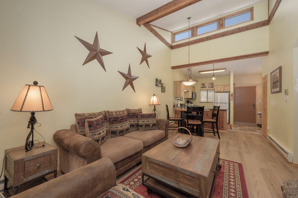 Relax in your rustic retreat with exposed beams, cozy seating, and western charm throughout this open-plan living space.