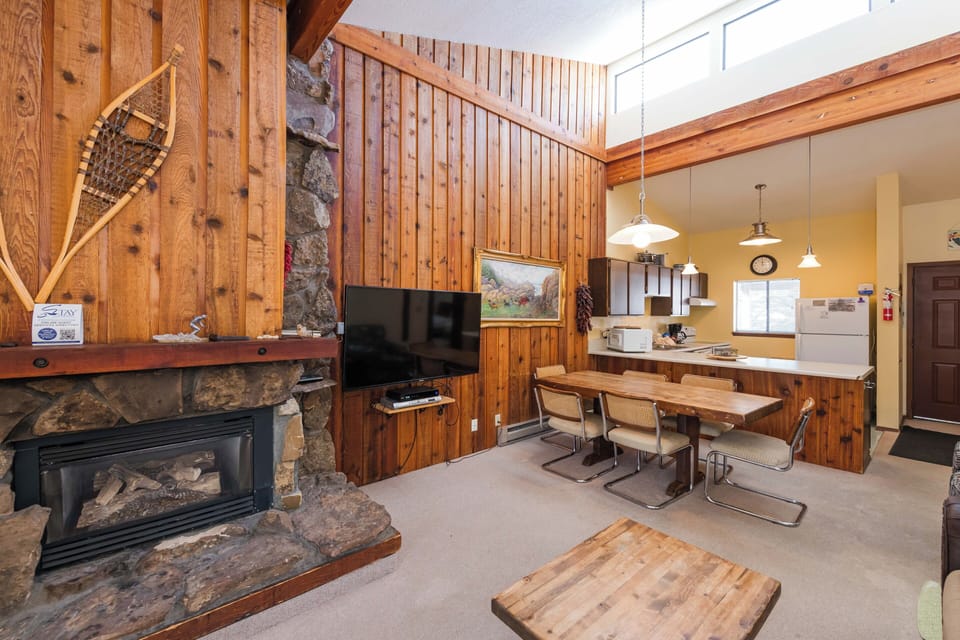 Gather around your wood-burning fireplace in this cozy mountain retreat, where rustic charm meets modern comfort in an open-concept living space.