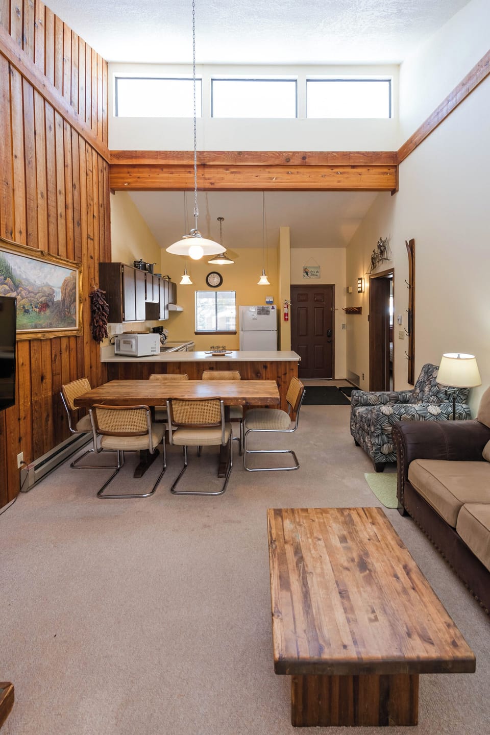 Your spacious open-concept retreat features warm wood accents, a dining table for family meals, and a cozy living area perfect for relaxation.