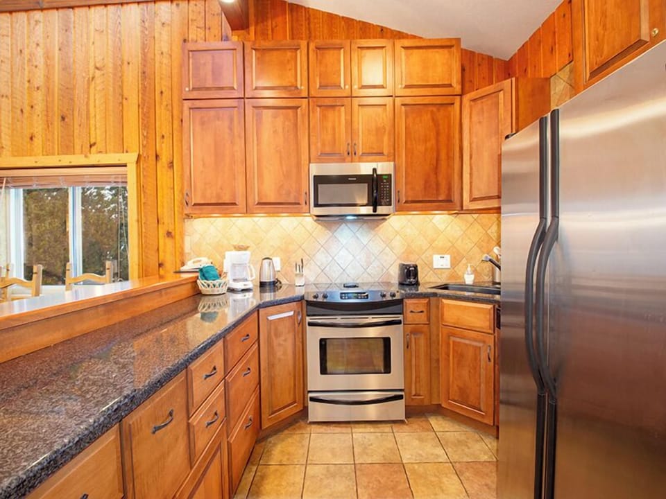 Step into your fully equipped mountain kitchen with granite counters, stainless appliances, and warm wood cabinets for memorable meals.