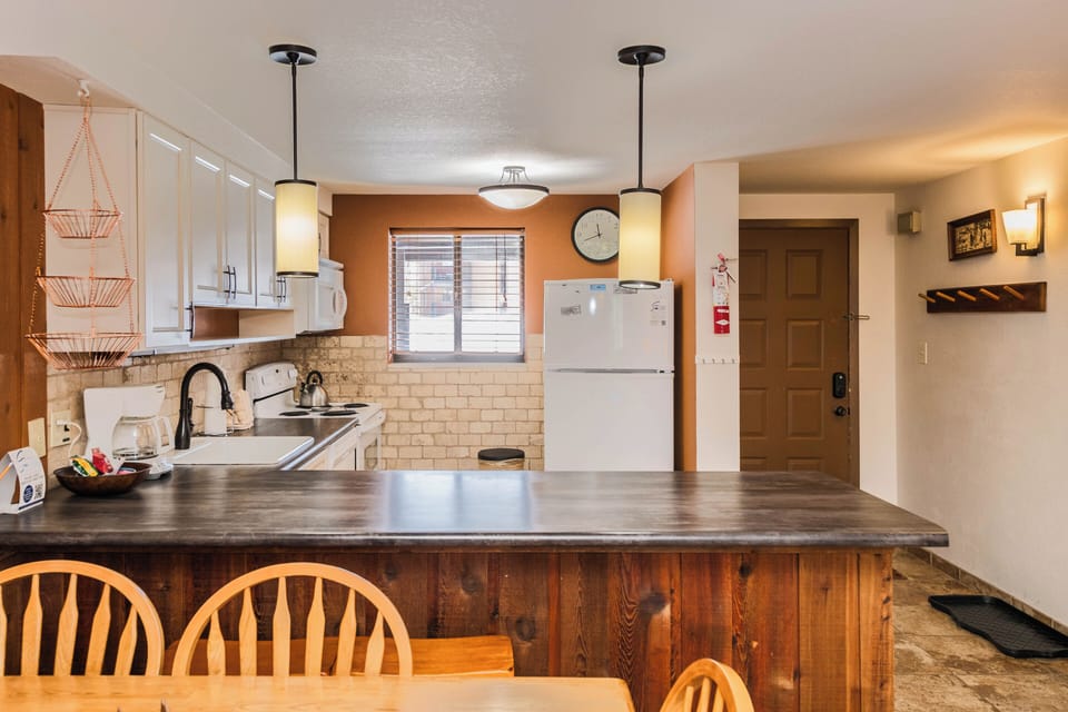 Your spacious kitchen invites culinary adventures with modern appliances, warm wood finishes, and a breakfast bar where morning coffee tastes better.