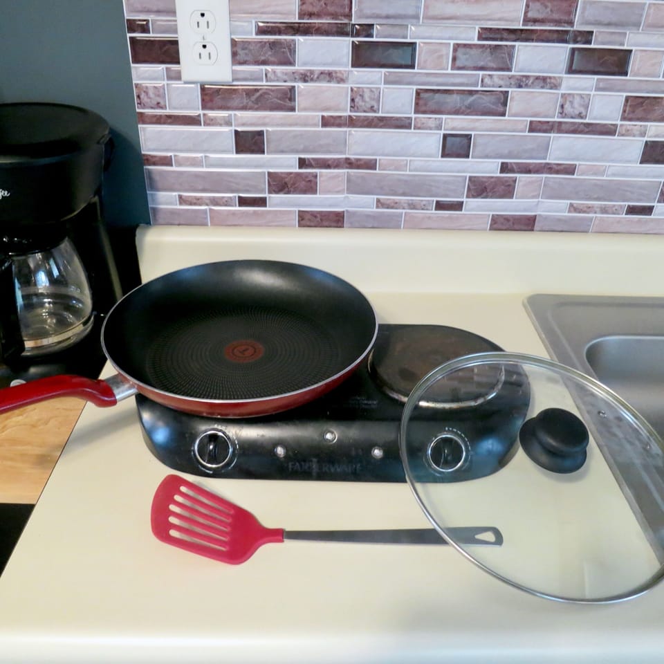2 burner stove top with pots/pans, crockpot, and toaster