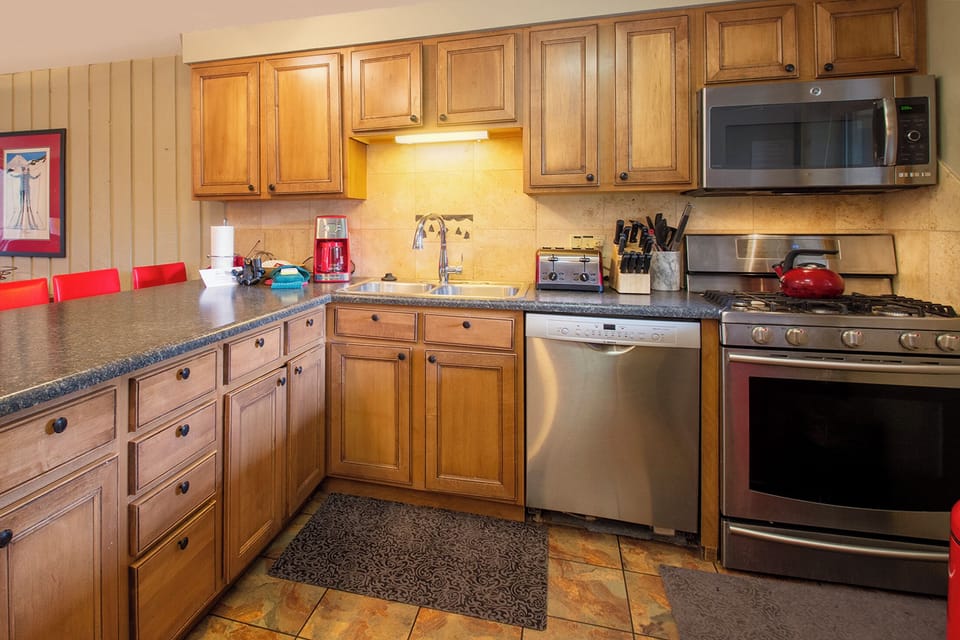 Your fully equipped kitchen welcomes you with warm wood cabinets, granite counters, and stainless steel appliances for effortless cooking.