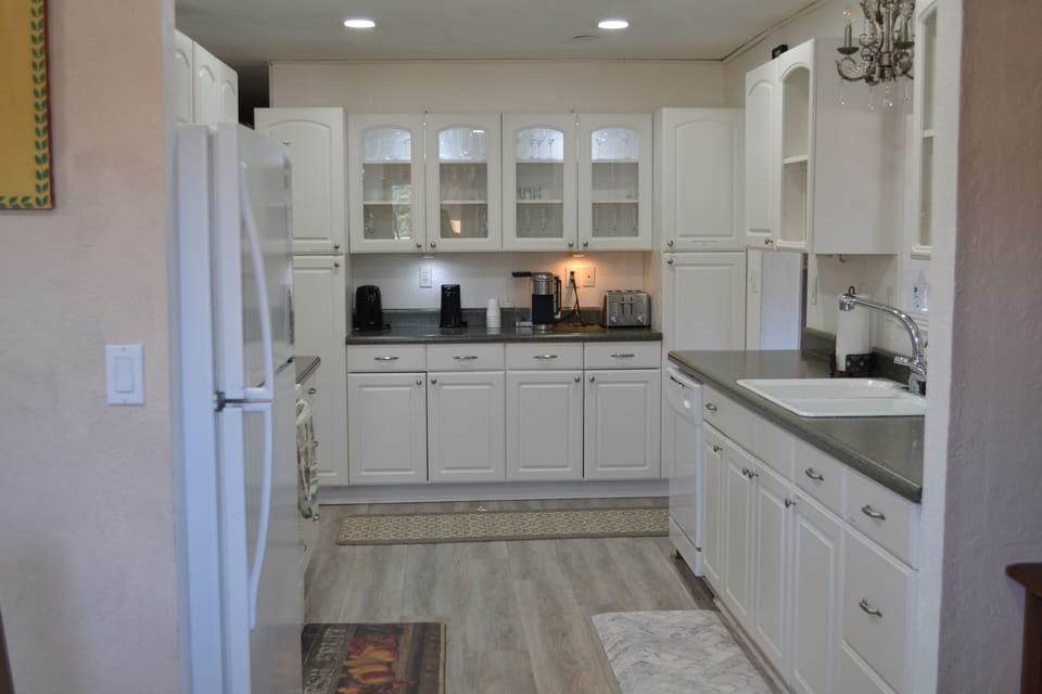 Kitchen has dishwasher, sink, refrigerator, and electric stove with oven. 